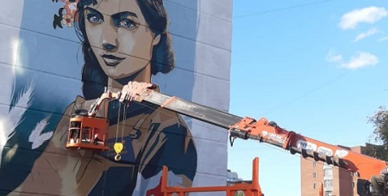 Заканчивают расписывать стену дома в Бердске молодые граффитисты